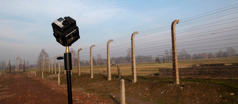 Eine 360°-Kamera auf einem Stativ im ehemaligen Konzentrationslager Auschwitz-Birkenau